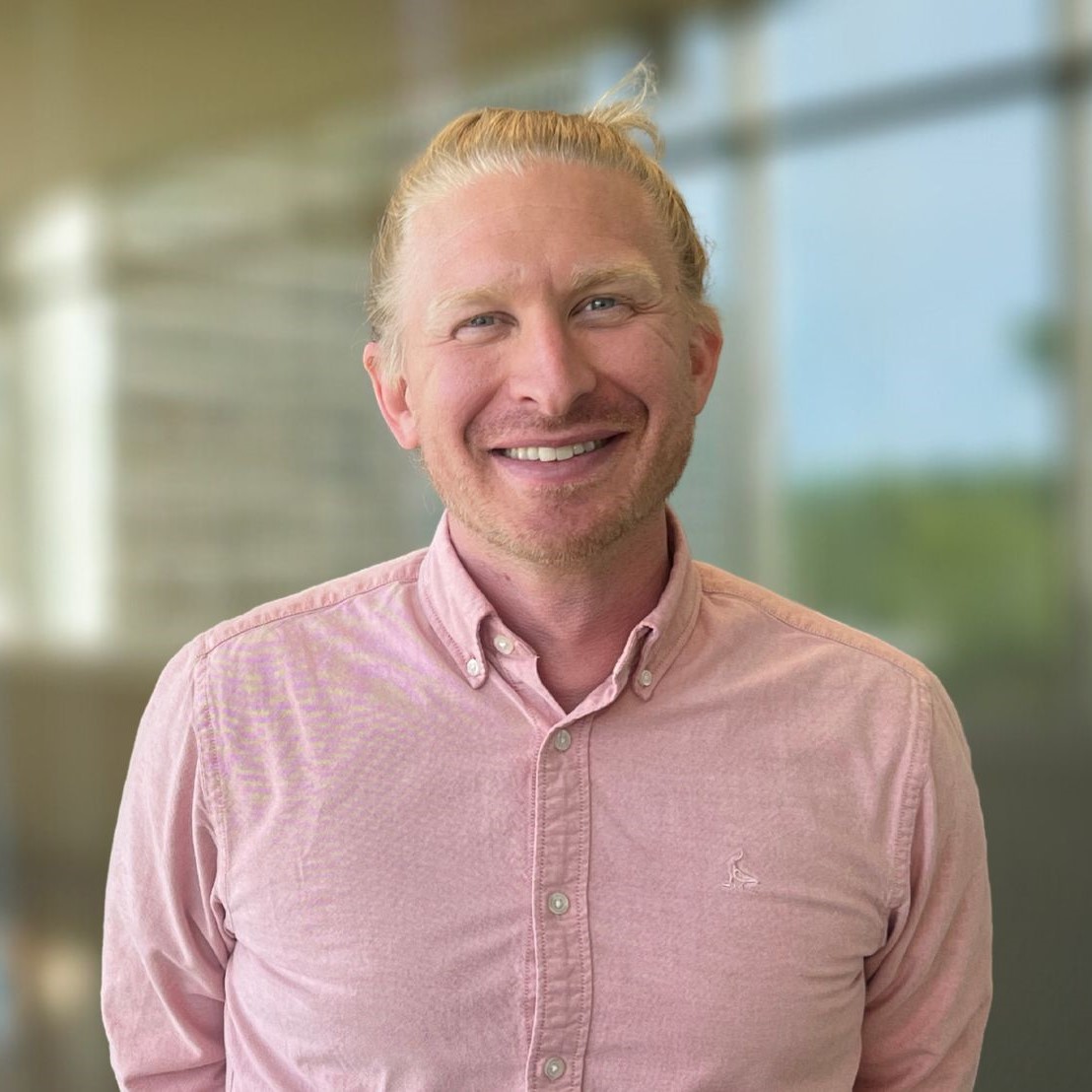 A portrait of Adam Courtney smiling